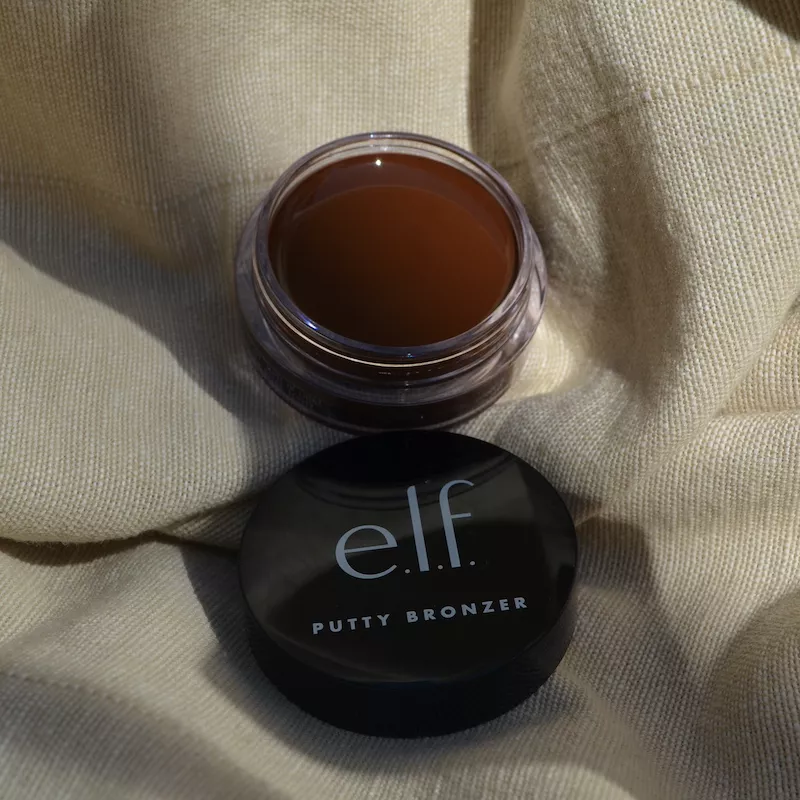 e.l.f. Cosmetics Putty Bronzer in Sun Kissed open jar on fabric background