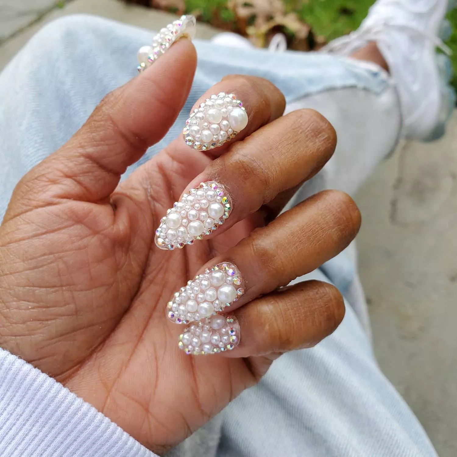 Manicure covered in various sizes of pearls and iridescent studs
