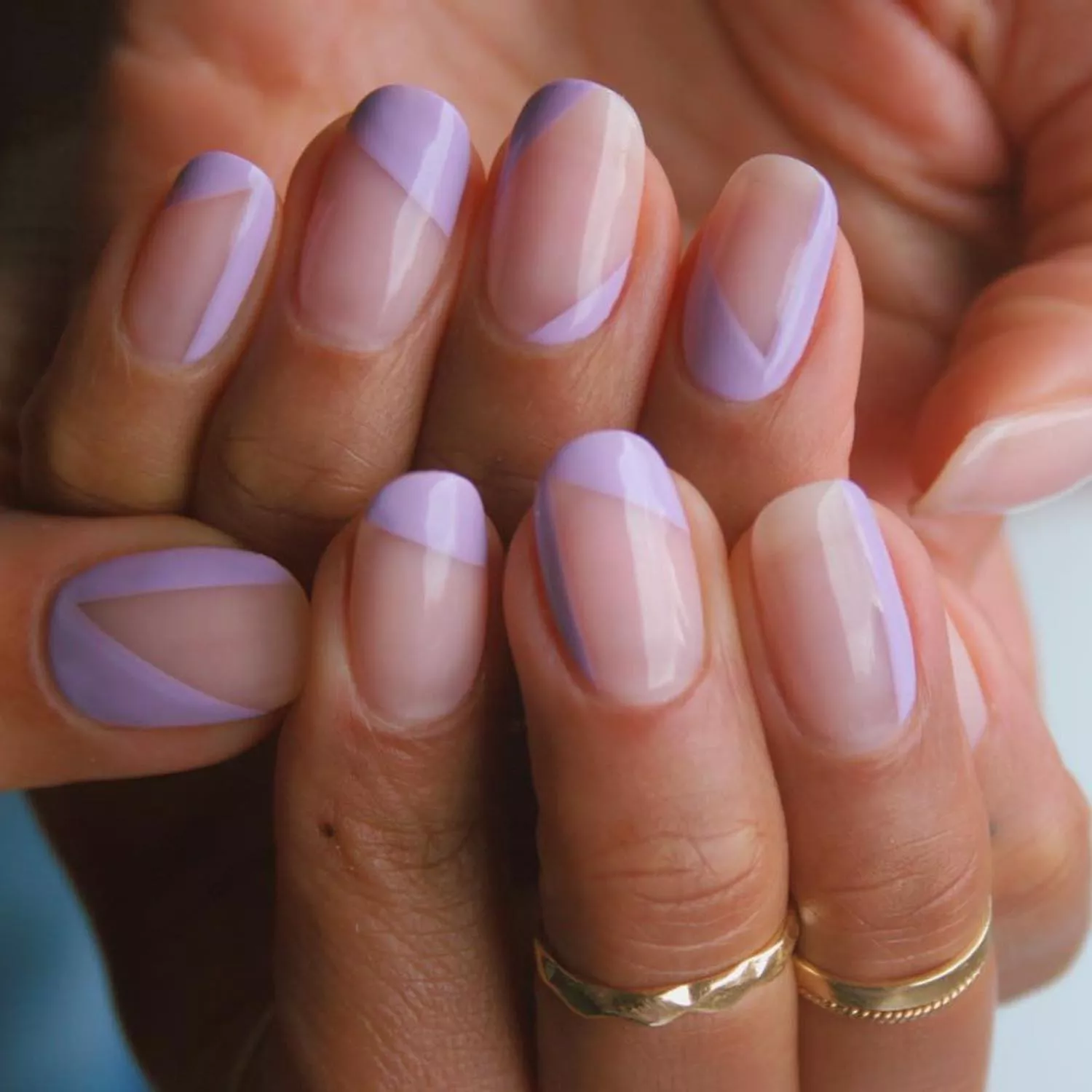Manicure with neutral translucent base and lavender abstract designs
