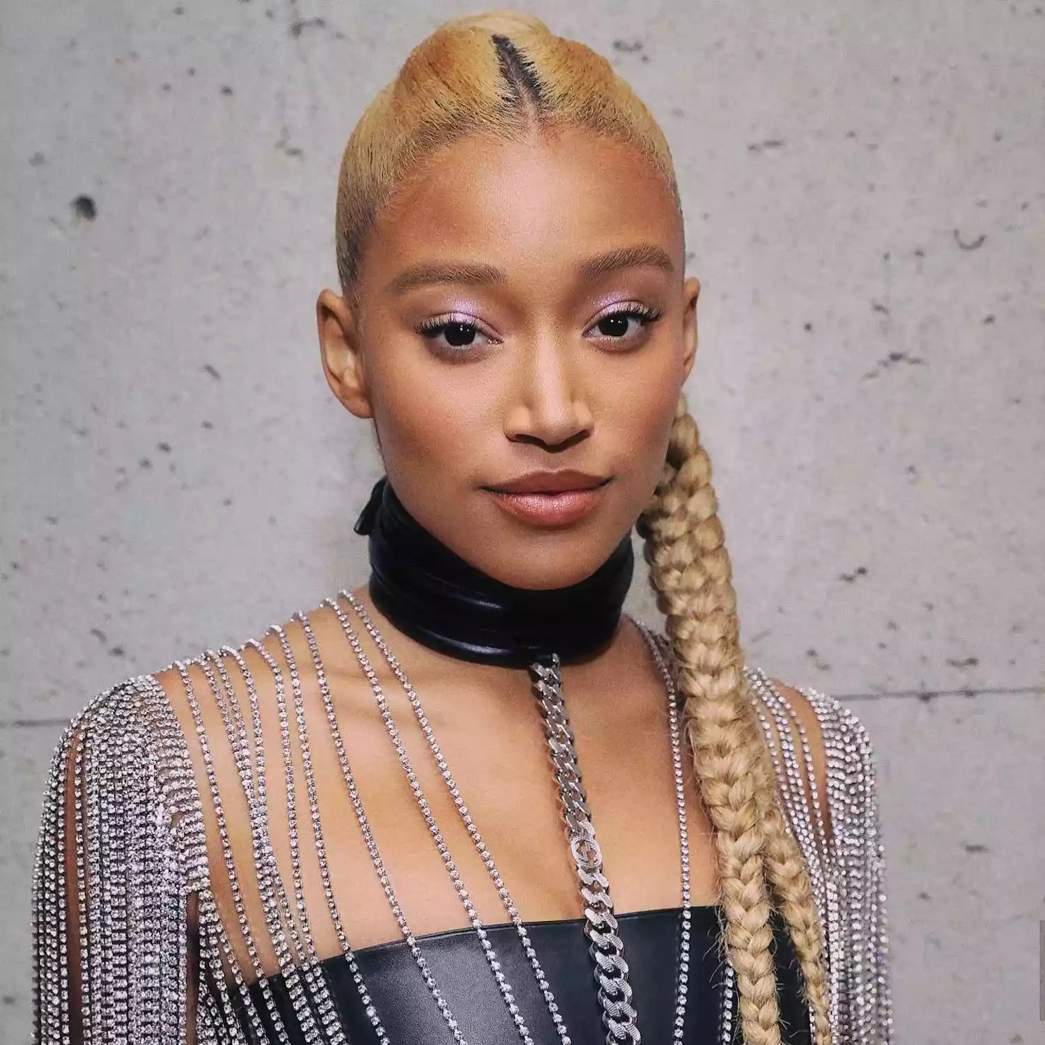 Amandla Stenberg with bright beige-toned blonde hair in a braided ponytail style 