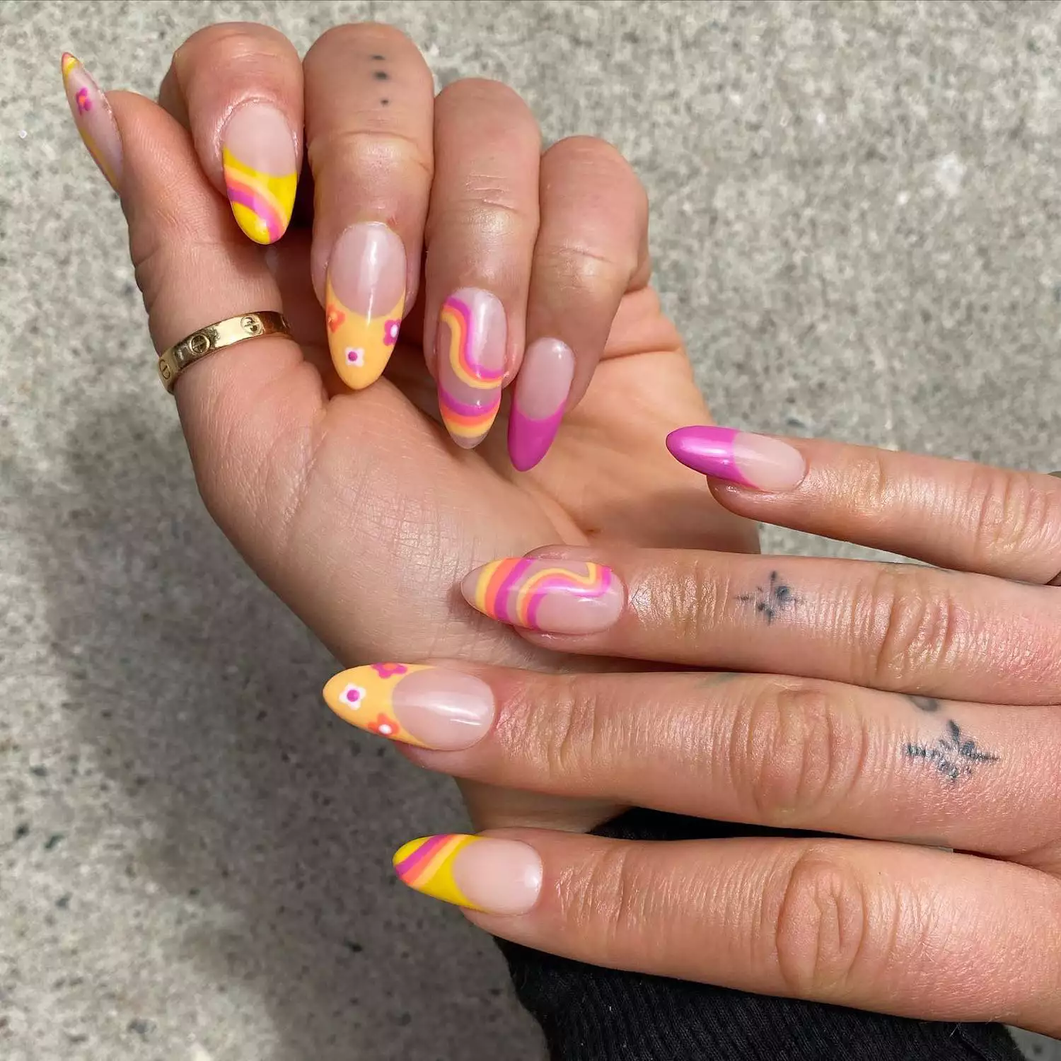 Manicure with assorted pink and yellow wave, floral, and French tip designs