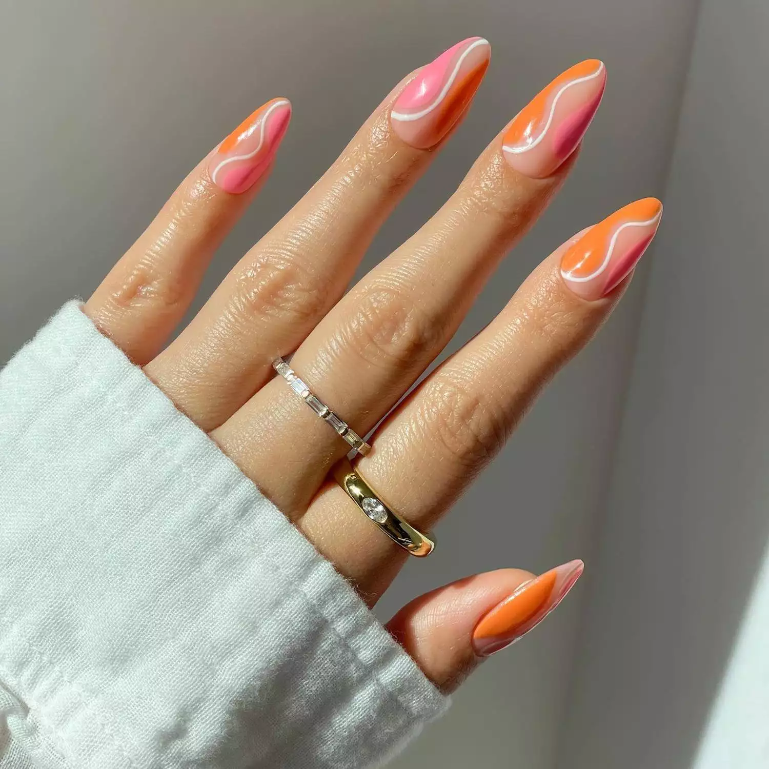 Manicure with abstract wavy pink and orange design with white accent lines