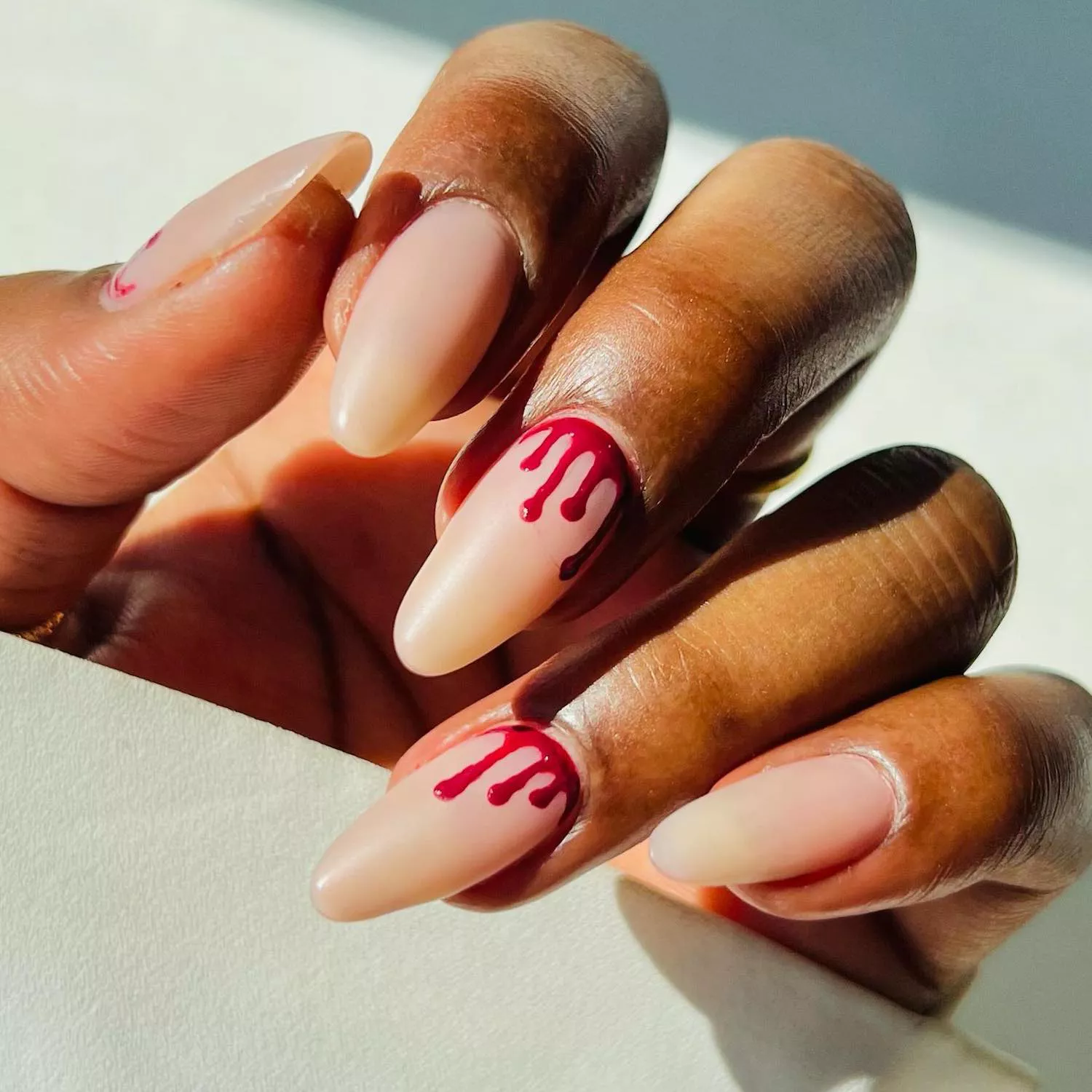 Manicure with translucent neutral base and blood tip cuticle accents
