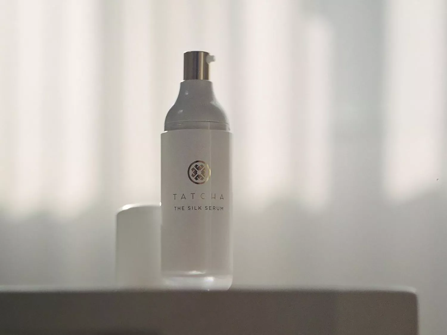 A bottle of Tatcha's The Silk Serum on a table