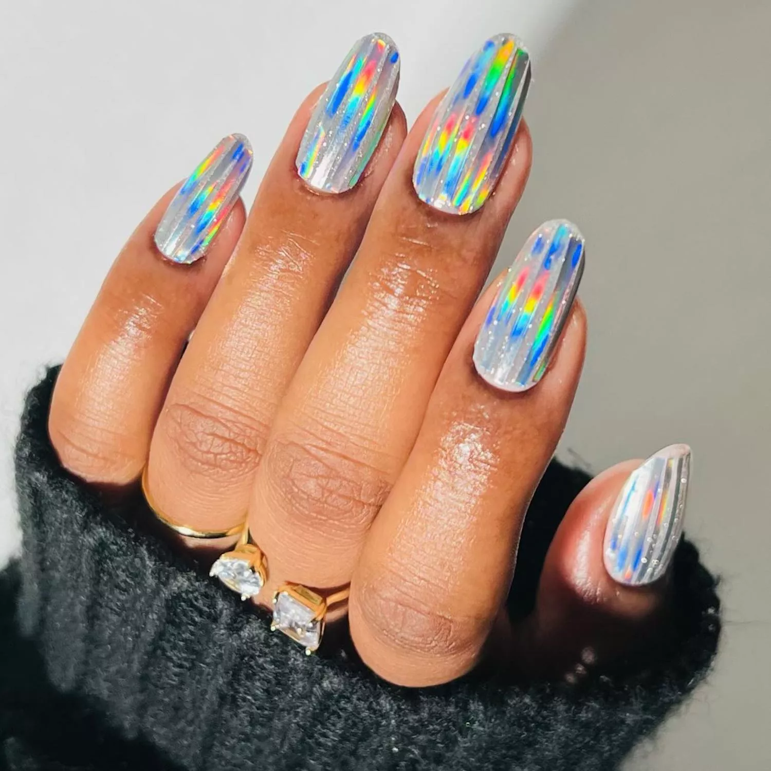 Manicure with sparkly silver base and rainbow iridescent strips