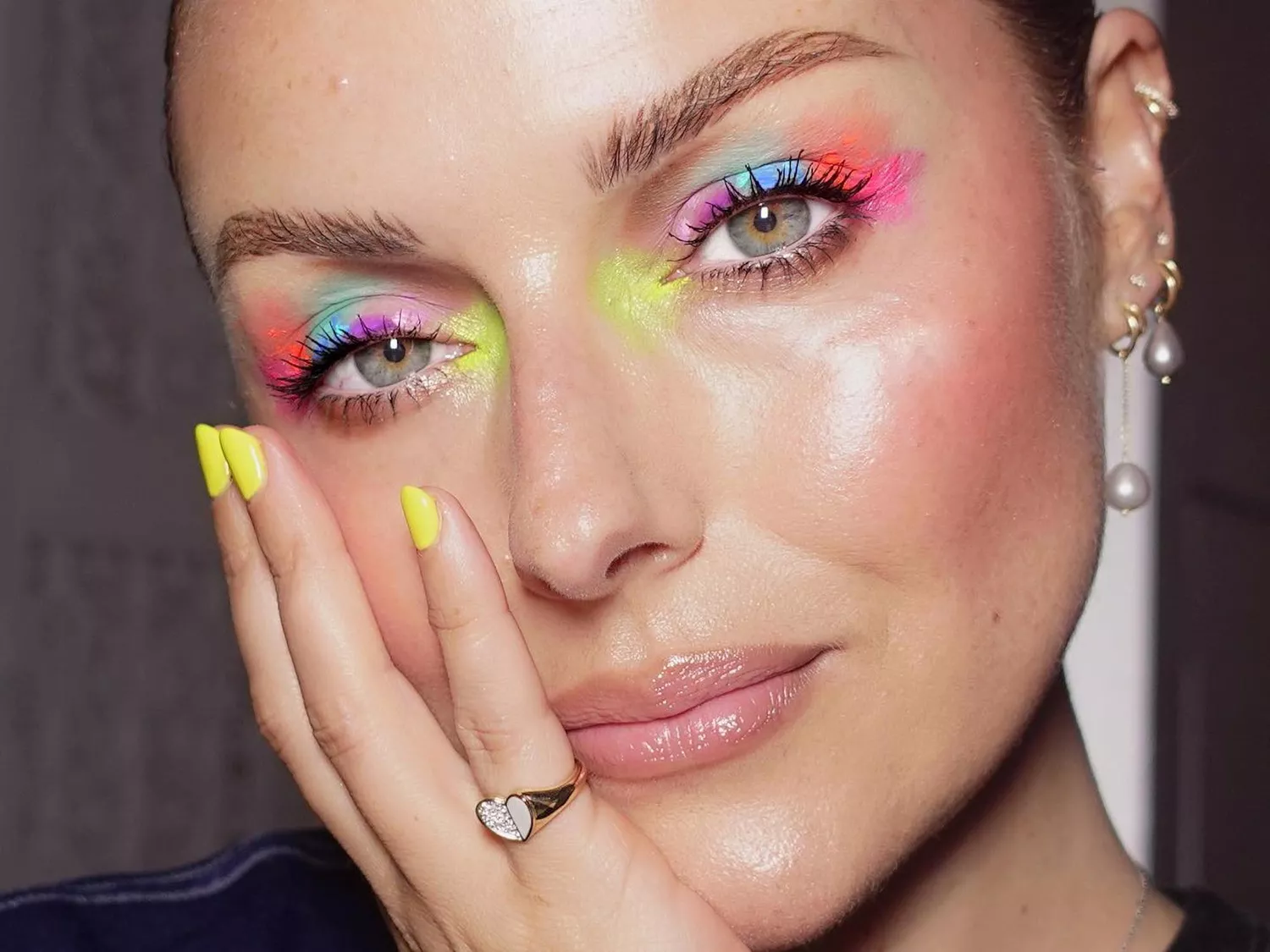 Makeup artist Katie Jane Hughes wears a neon watercolor splatter paint-inspired eye makeup look