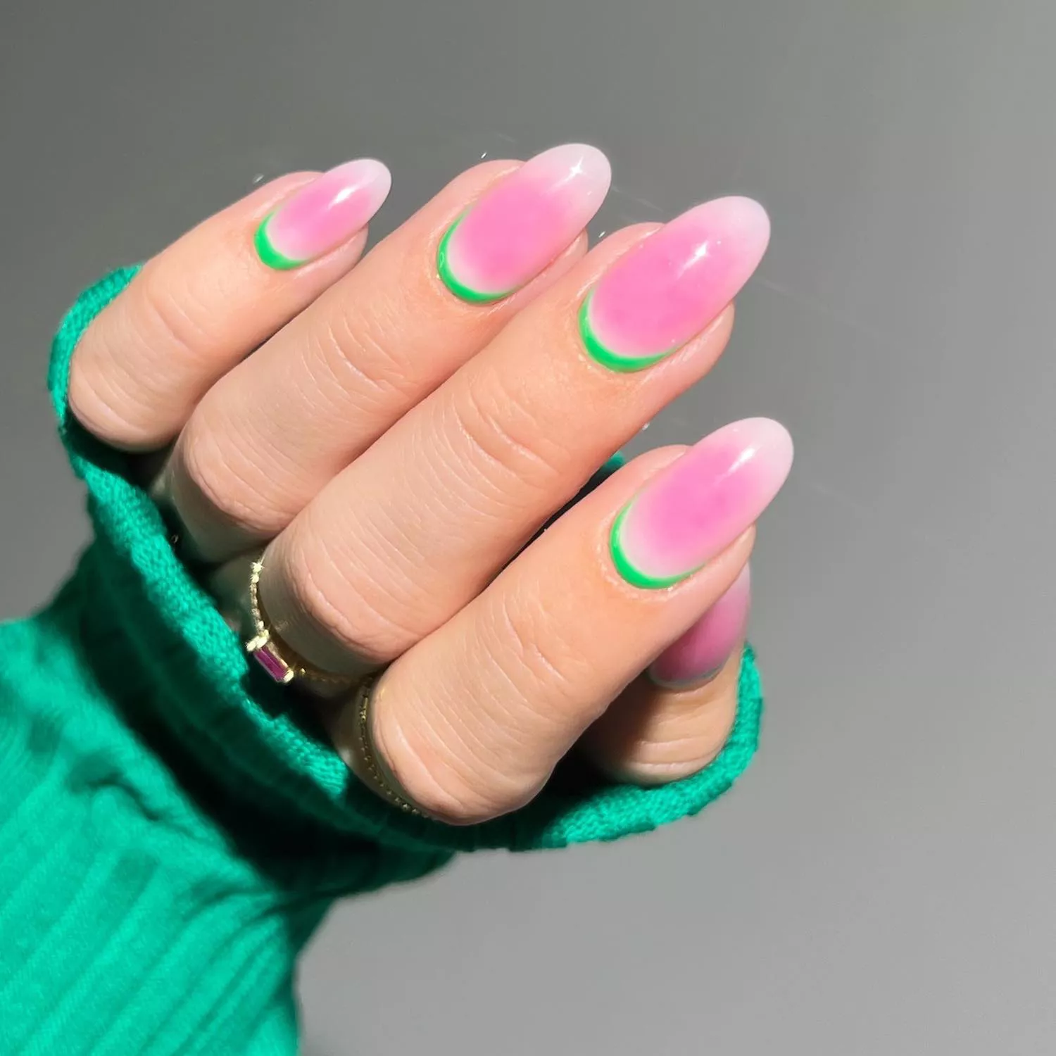 Manicure with muted watermelon pink blush base and neon green cuticle accents