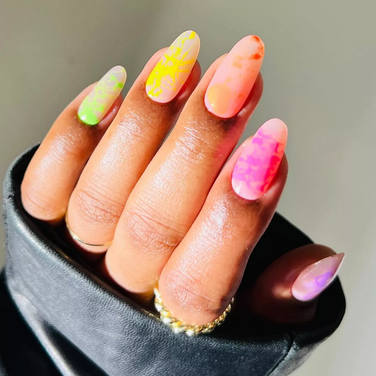 Manicure with translucent neutral base and multicolored neon splatter designs