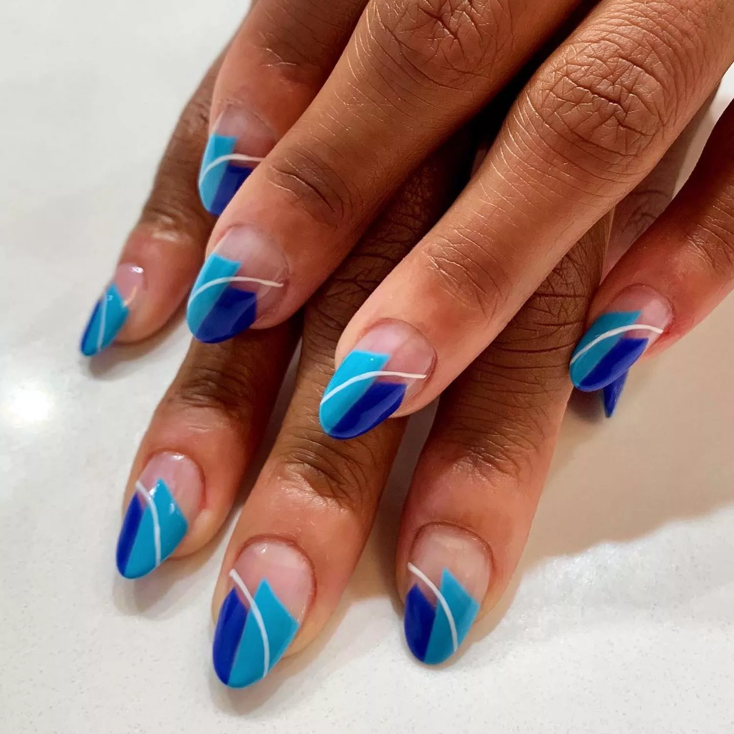 Manicure with blue geometric details and white accent line