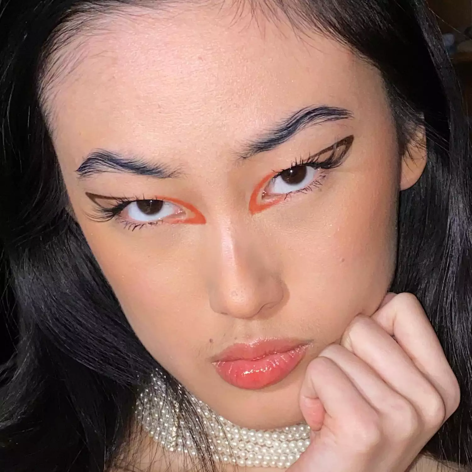close up of woman wearing wavy eyebrows and graphic eyeliner