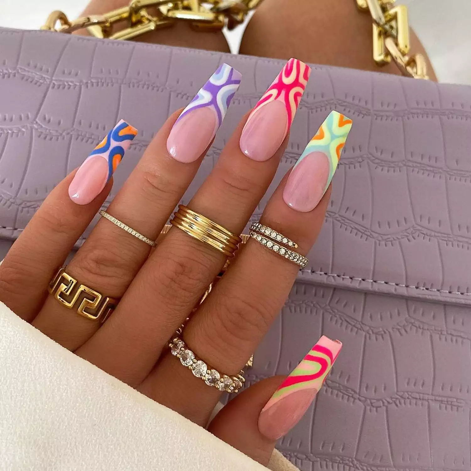 French manicure with mismatched colorful abstract designs on tips