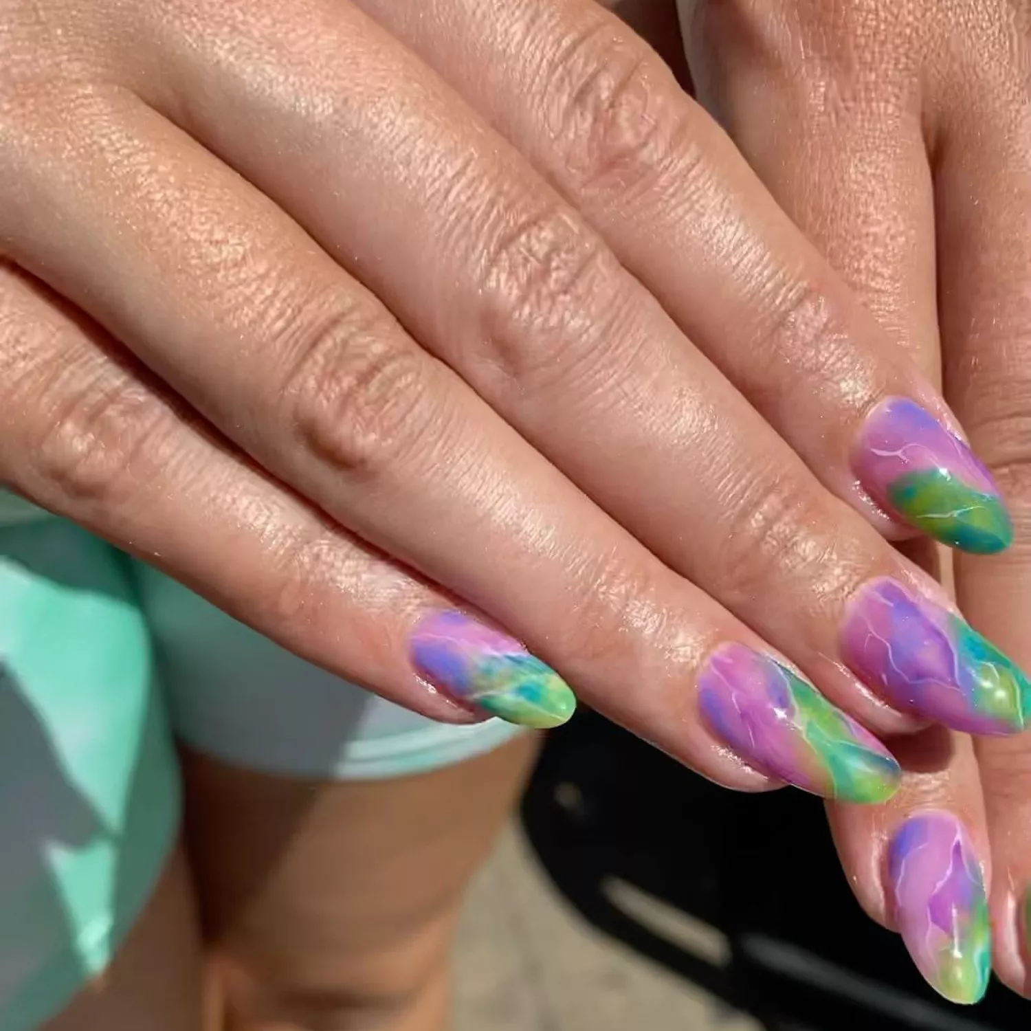 Purple and green marbled nail design