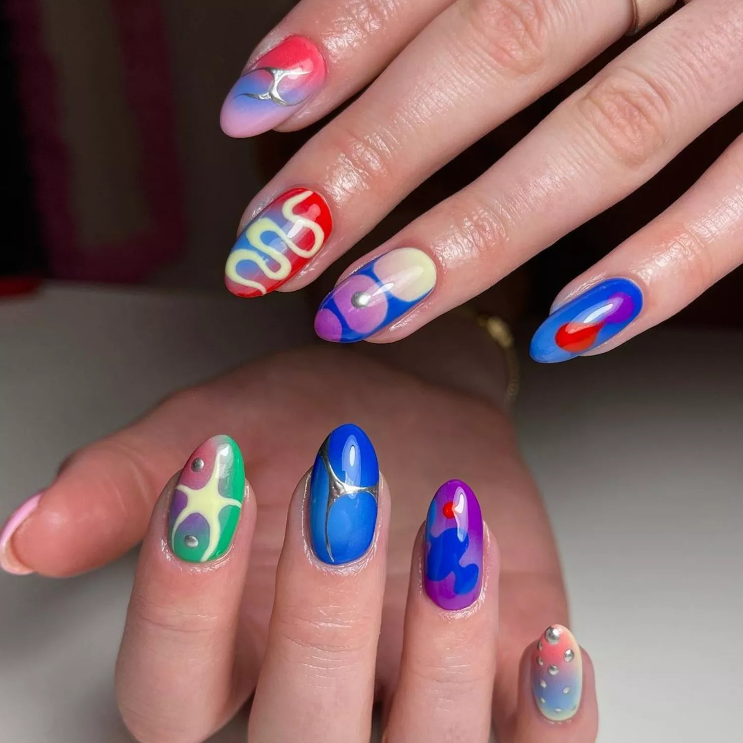 Aura manicure with mismatched colorful designs
