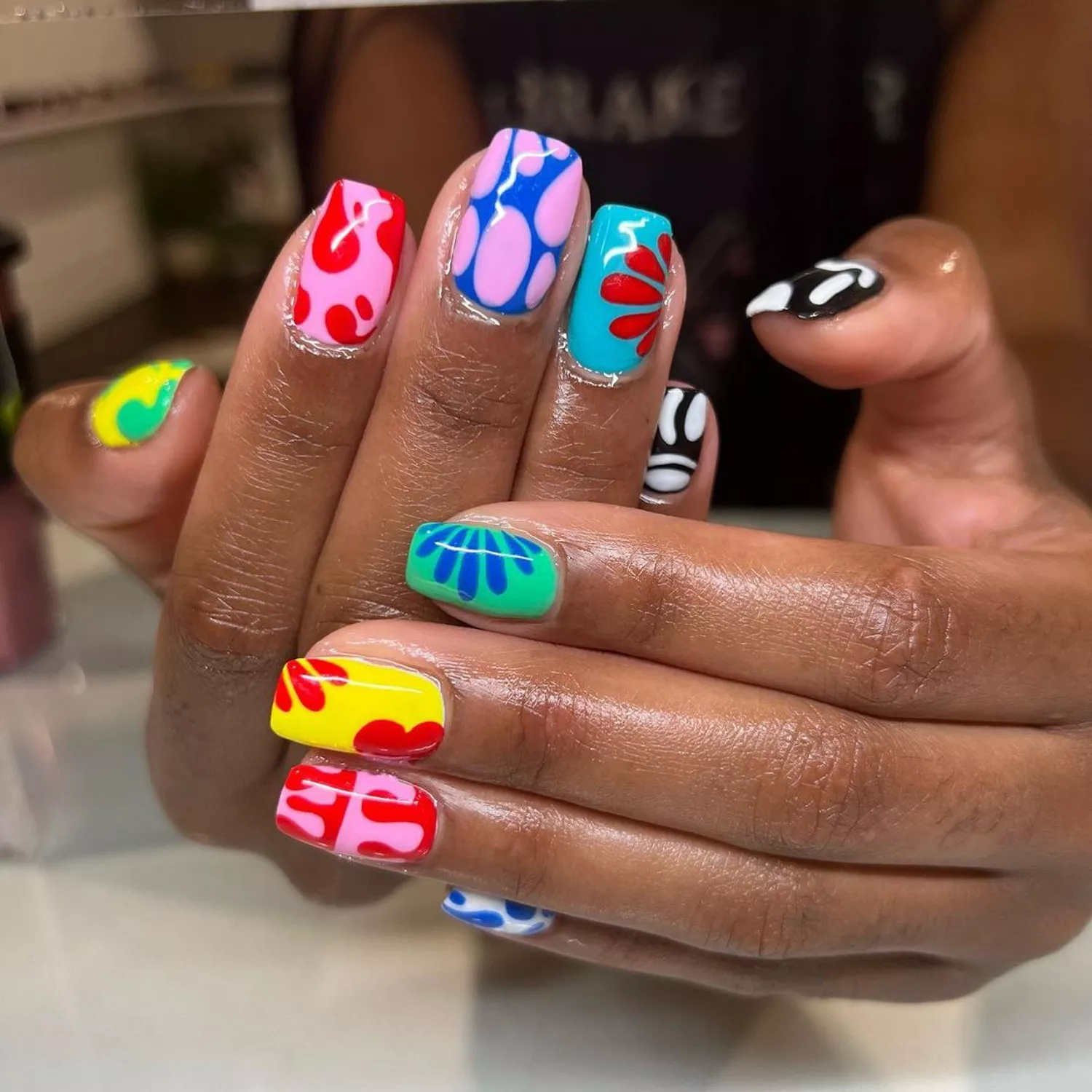 Manicure with mismatched multicolored flower and abstract designs