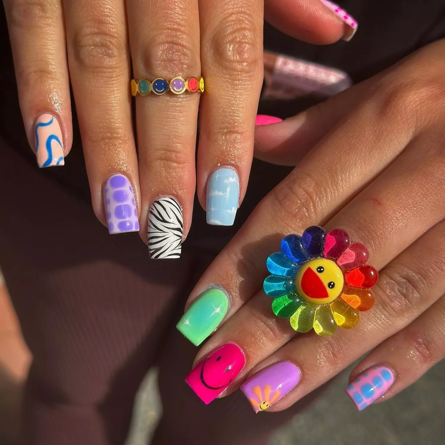 Manicure with abstract, sparkle, zebra print, smiley, cloud, and floral designs