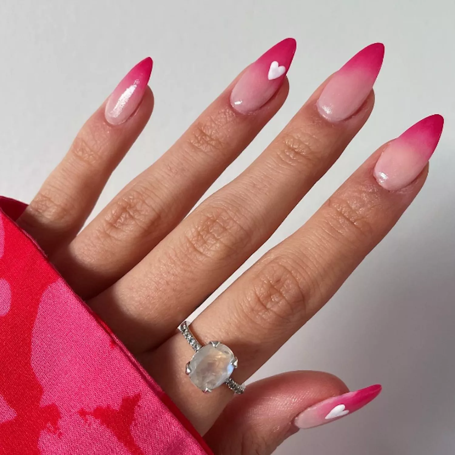 light pink and dark pink ombre manicure with heart on ring finger 