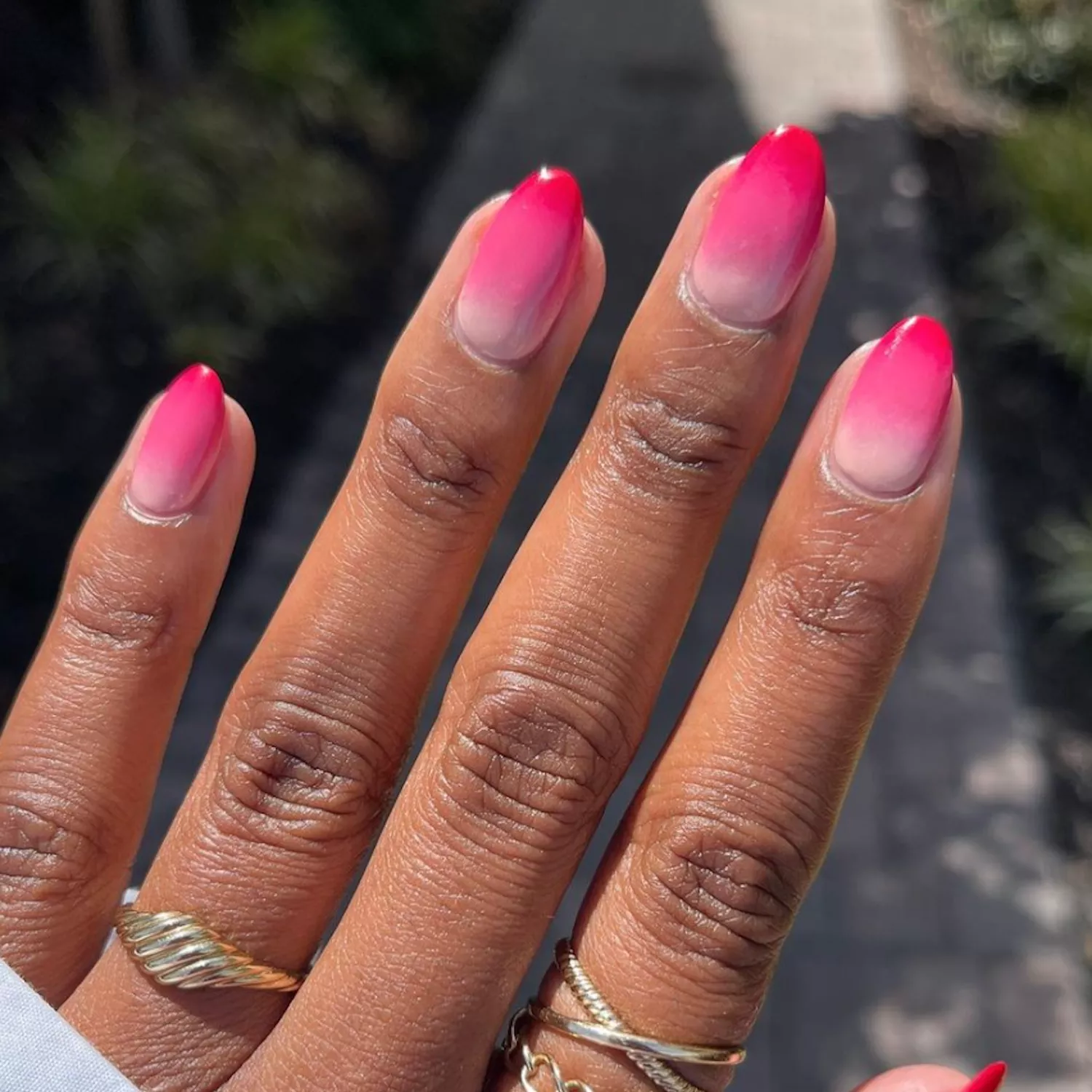 close up of woman's hand with light to dark pink ombre manicure