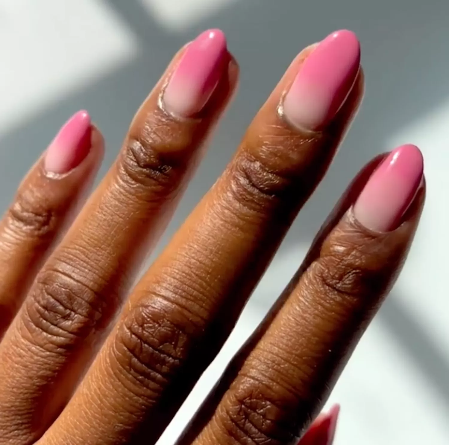 close up of manicure that fades from light pink to dark pink