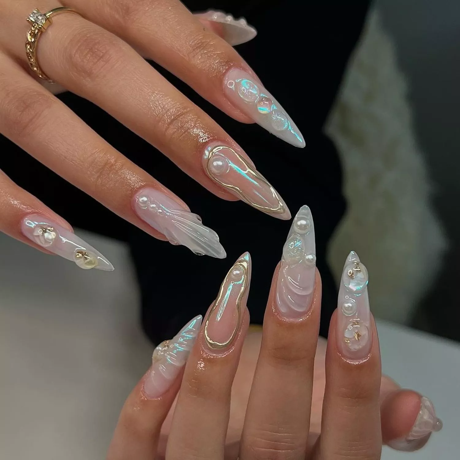 Pearlescent acrylic nails with 3D sculpted details, pearls, and gold accents