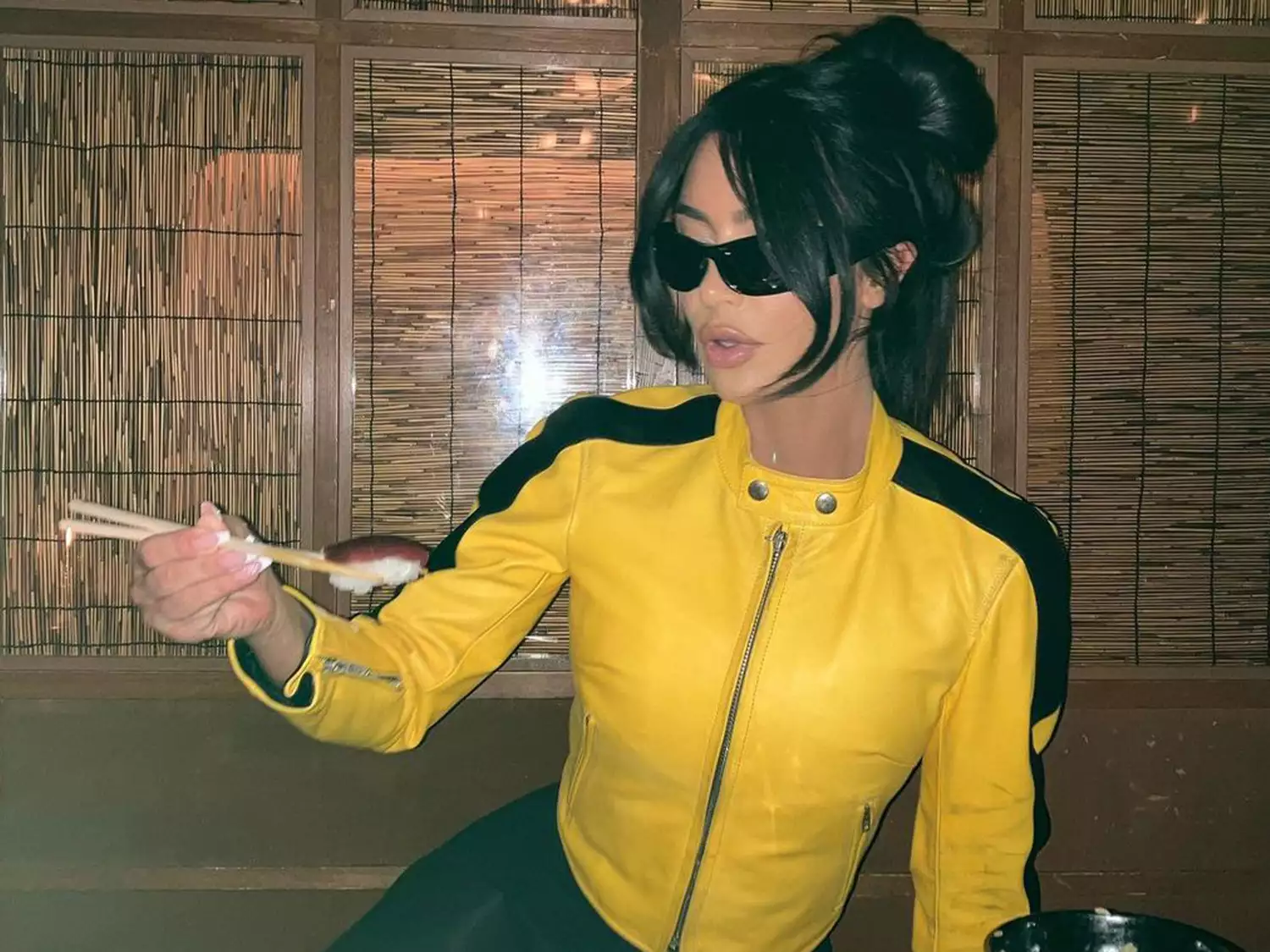 Kim Kardashian wearing a yellow jacket and curve bangs 