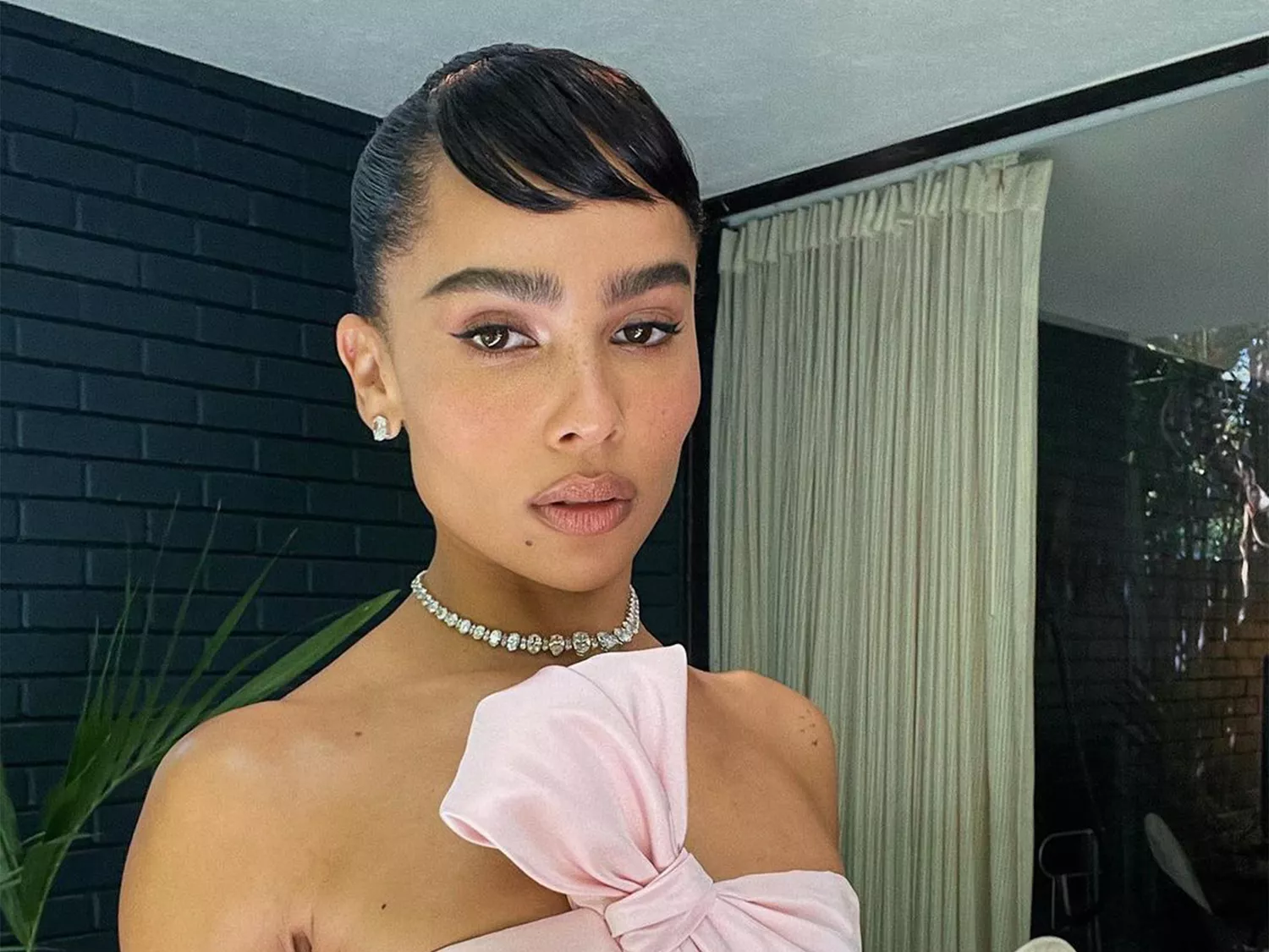 Zoe Kravitz in a pink dress with Hepburn bangs 