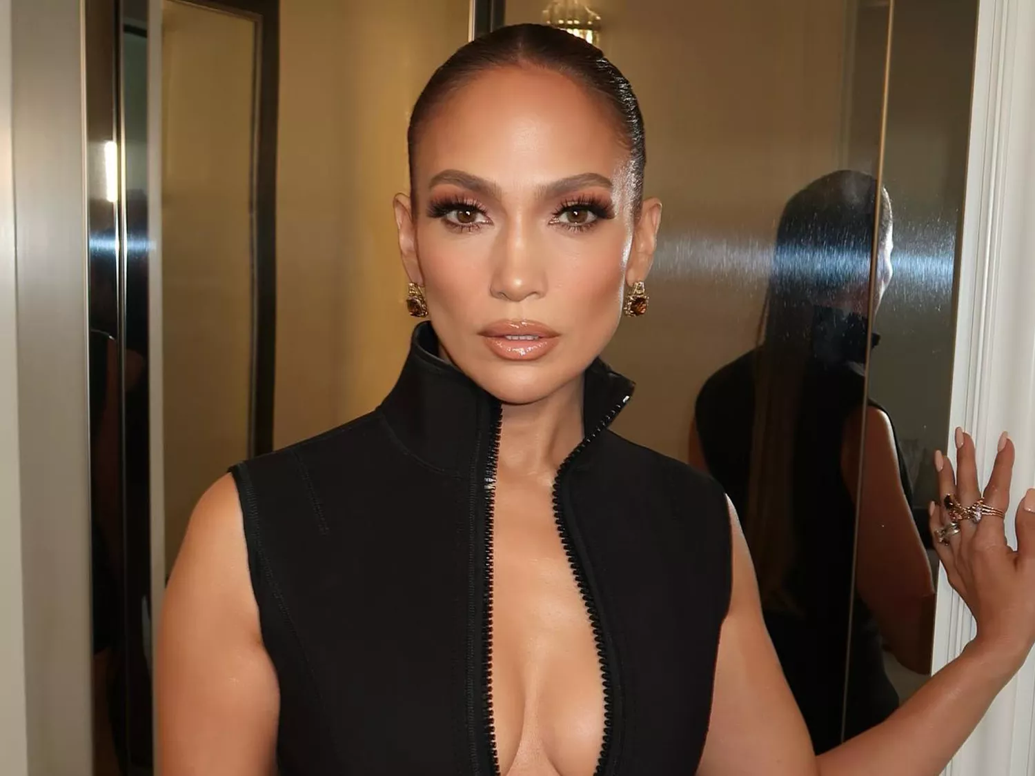 Jennifer Lopez wearing a black dress and peaches and cream manicure 