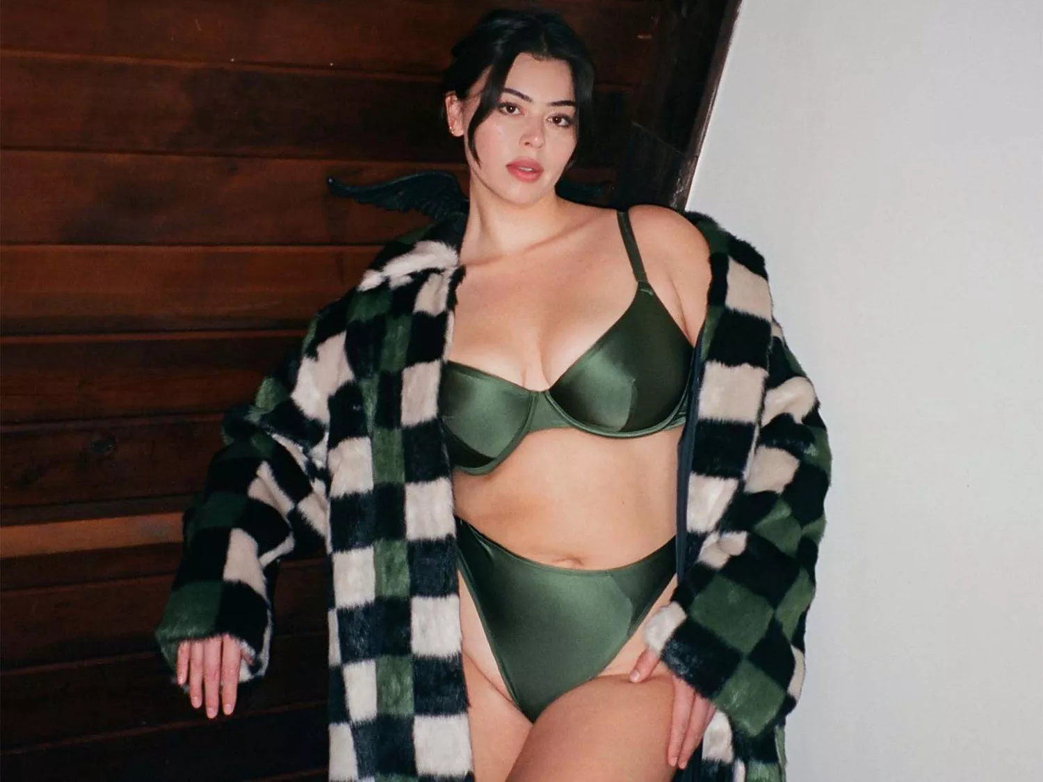 Lauren Chan wearing a green bra and fur coat