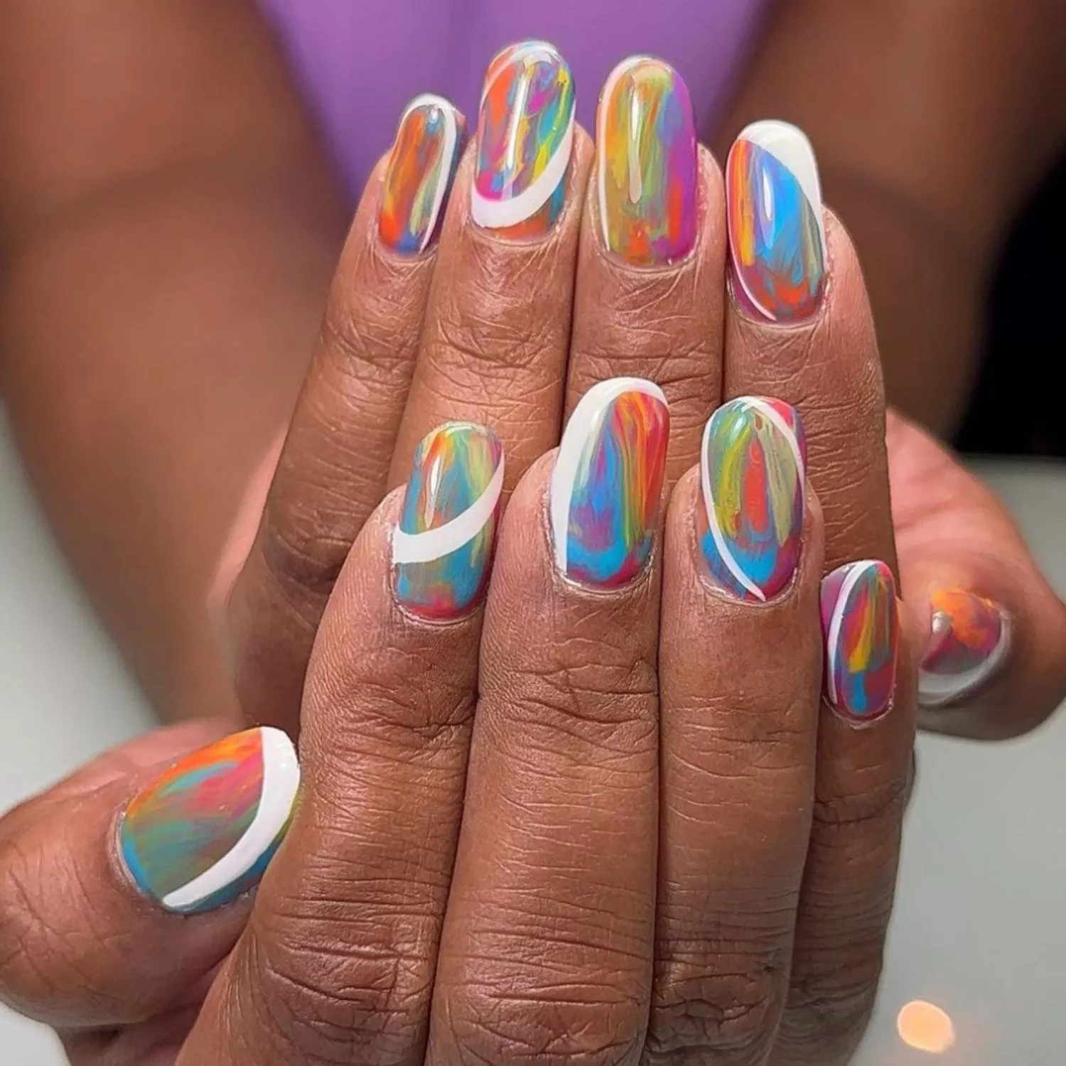 Colorful marbled tie-dye nails with white accent lines throughout