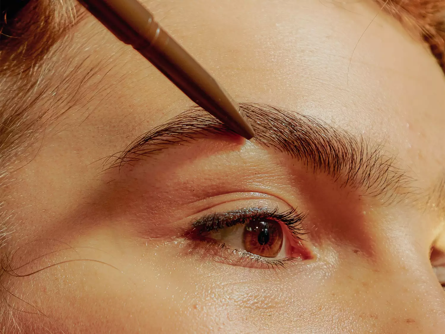 Woman applying eyebrow makeup 