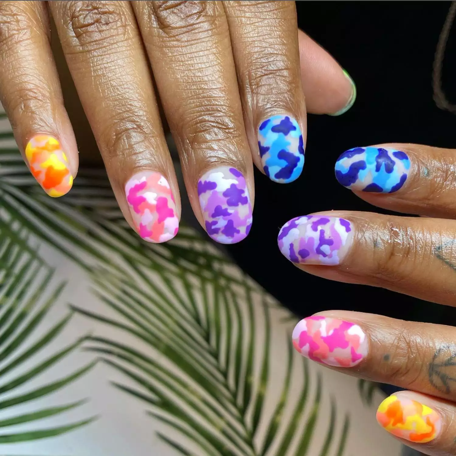 Camouflage print nails in neon green, blue, purple, pink, and orange