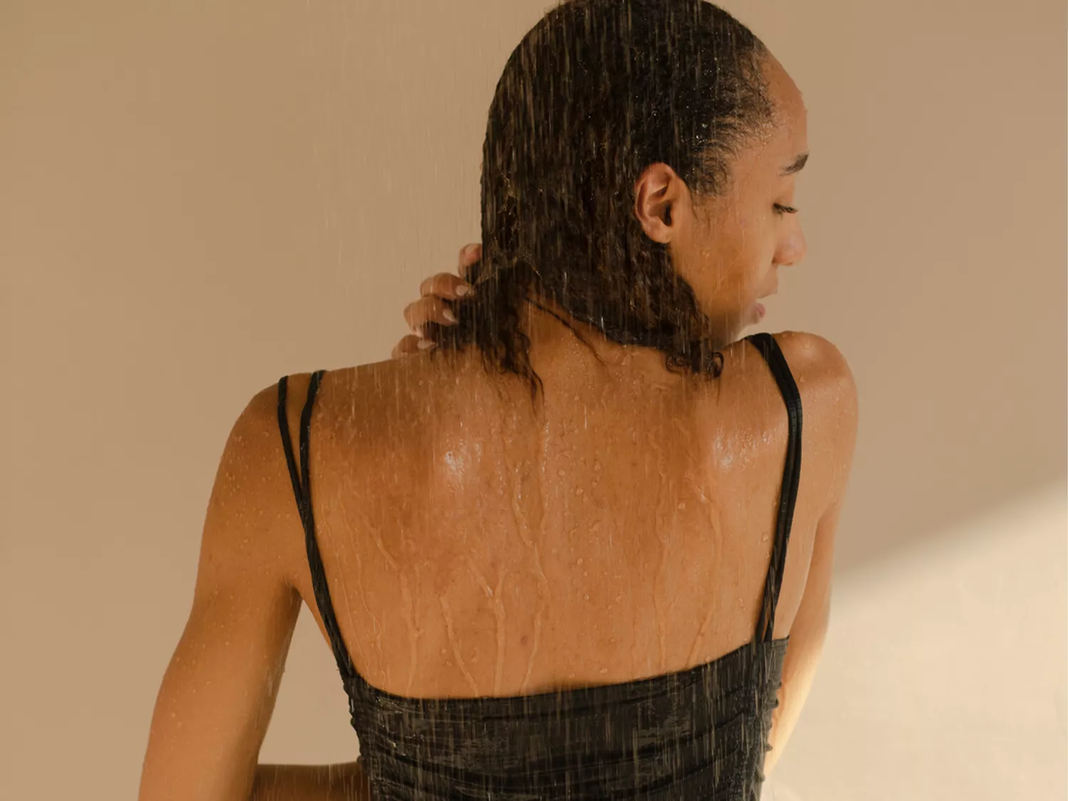 woman in shower with black bathing suit